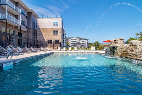 a person swimming in a pool with a building in the background