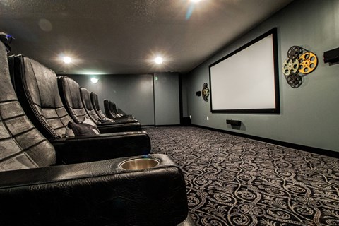 a home theater room with leather seats and a projector screen