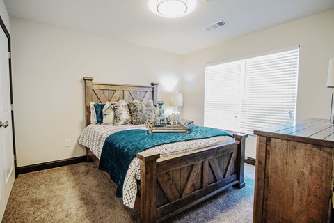 a bedroom with a bed and a dresser and a window