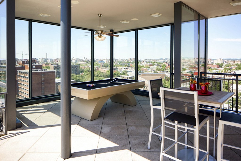 a living room with a pool table and a view of the city