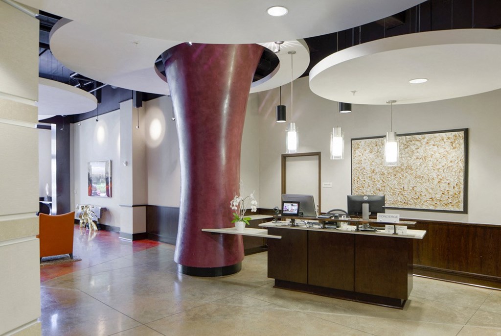 a lobby with a reception desk and a large red pillar