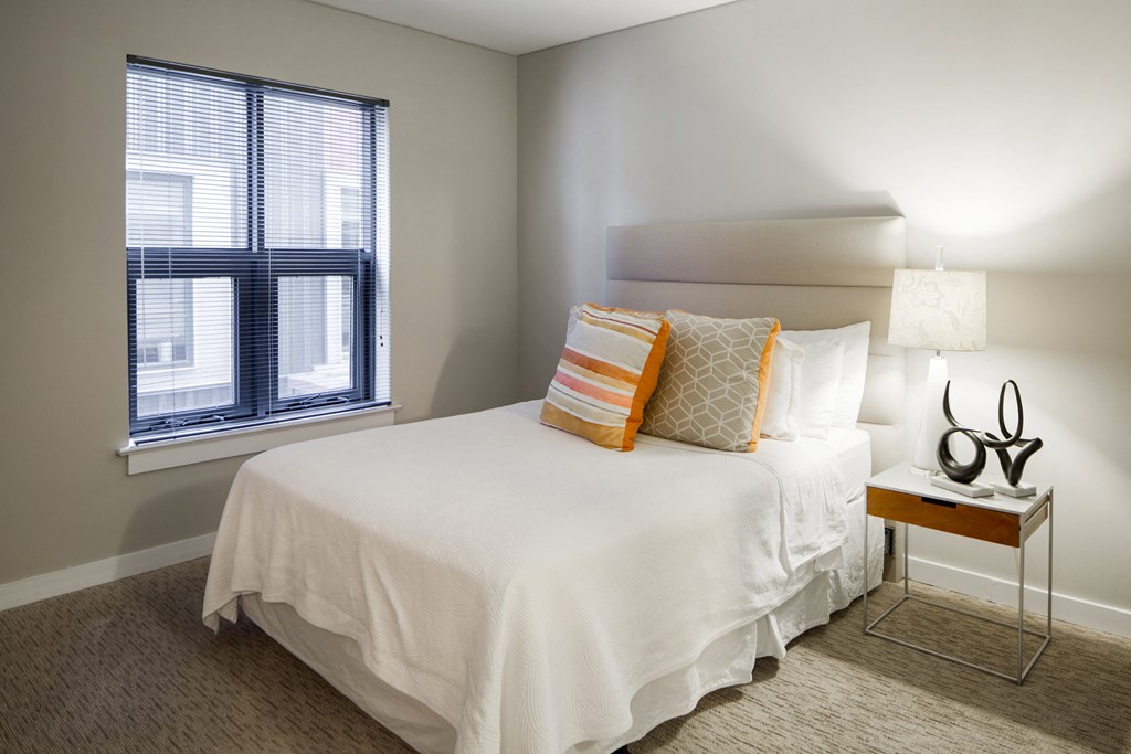 a bedroom with a large white bed and a window