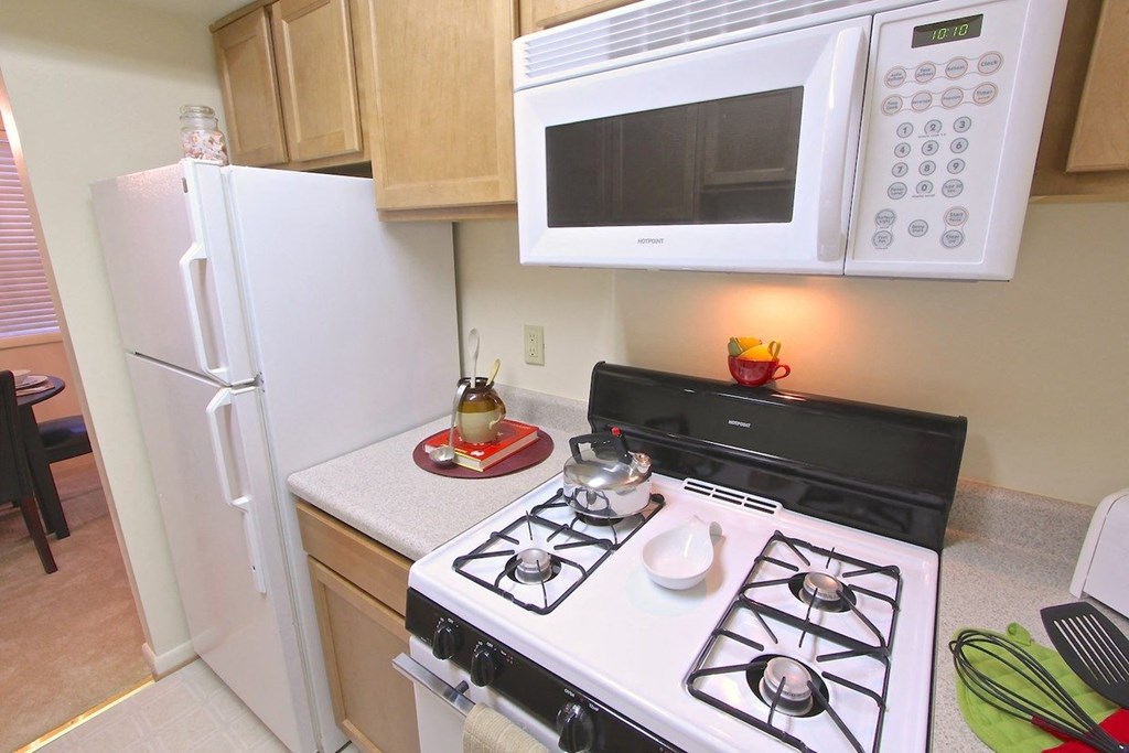 a small kitchen with a stove microwave and refrigerator