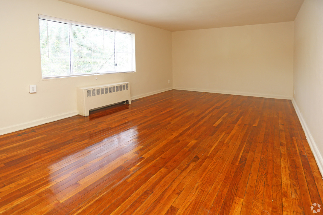 an empty living room with wooden floors and a window