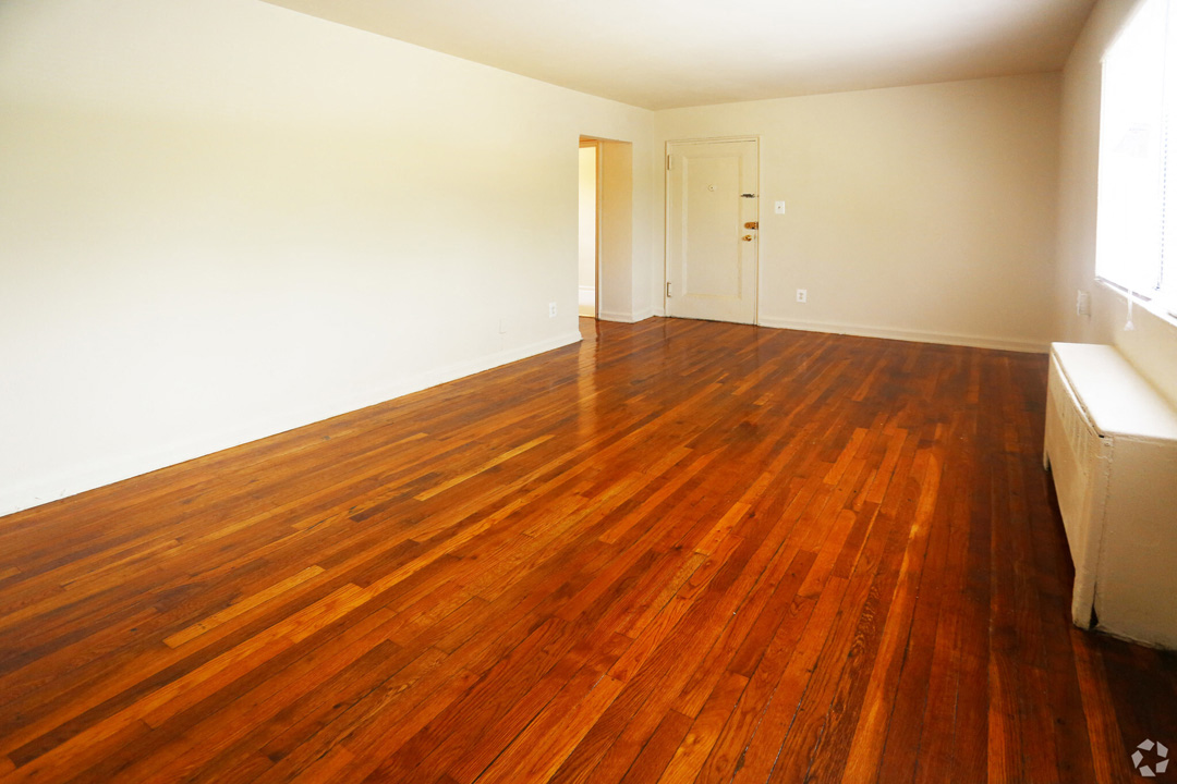 an empty living room with a wooden floor and a door
