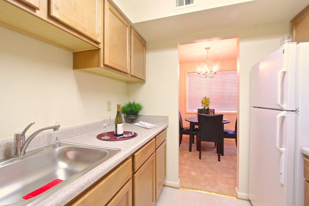 a kitchen with wooden cabinets and a stainless steel sink
