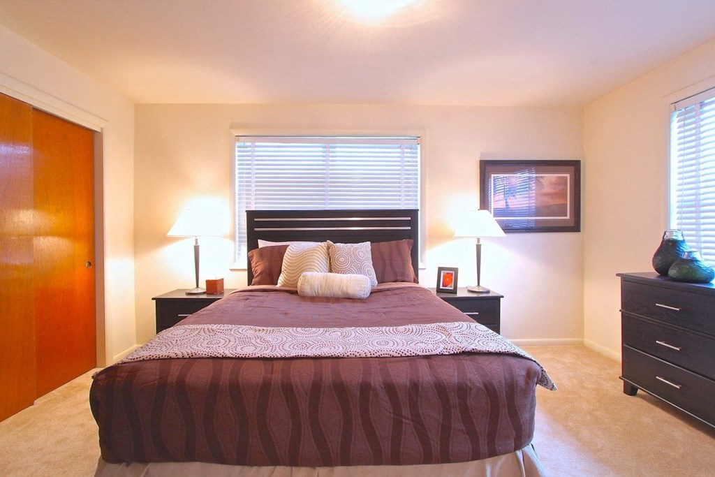 a bedroom with a large bed and two night stands with lamps