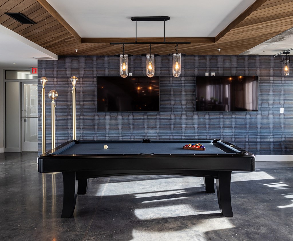 a pool table in a living room with blue tile and a tv