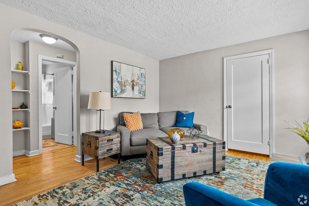 a living room with a couch and a chair and a rug