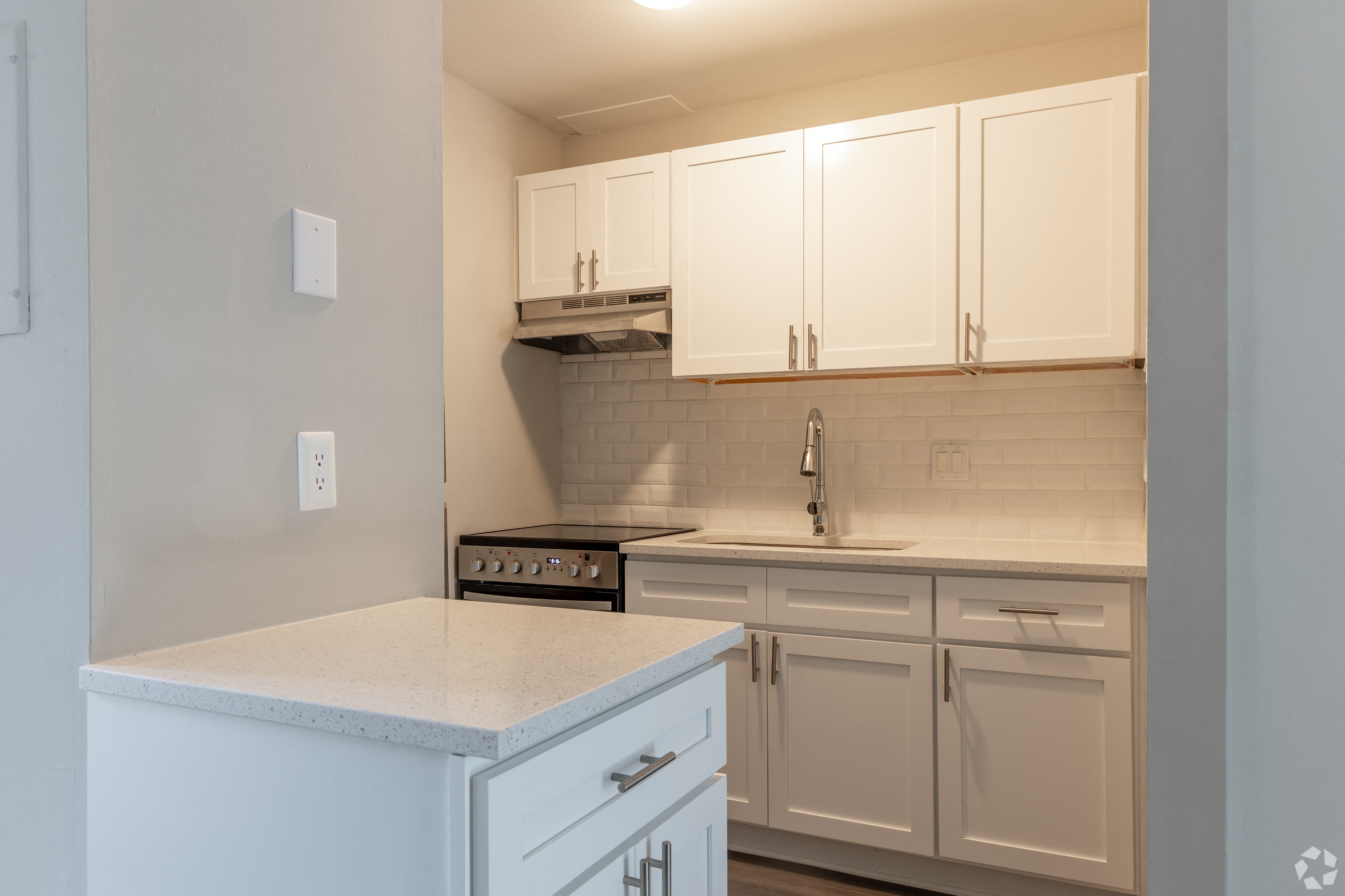 a kitchen with white cabinets and a counter top and a sink