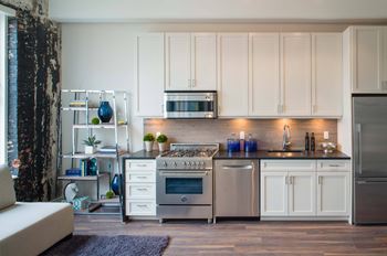 a kitchen with white cabinets and stainless steel appliances