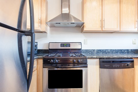 a kitchen with stainless steel appliances and wooden cabinets