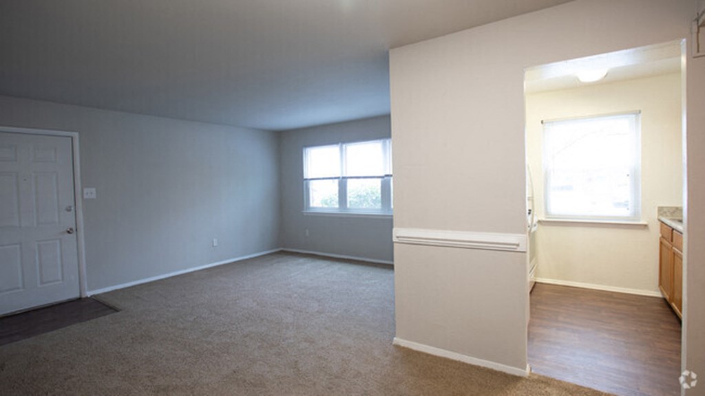 an empty living room with a window and a door