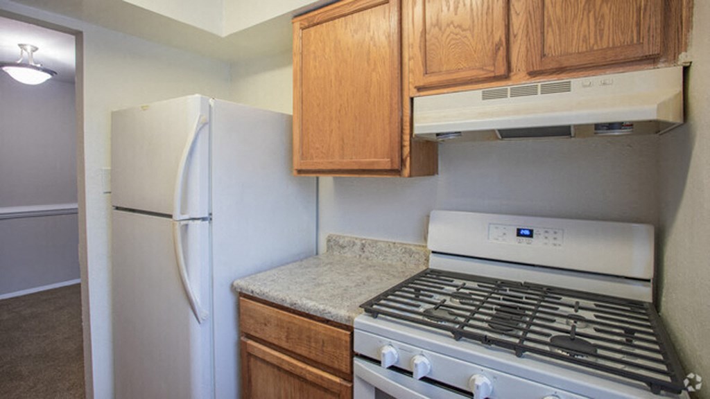 an empty kitchen with a stove and refrigerator