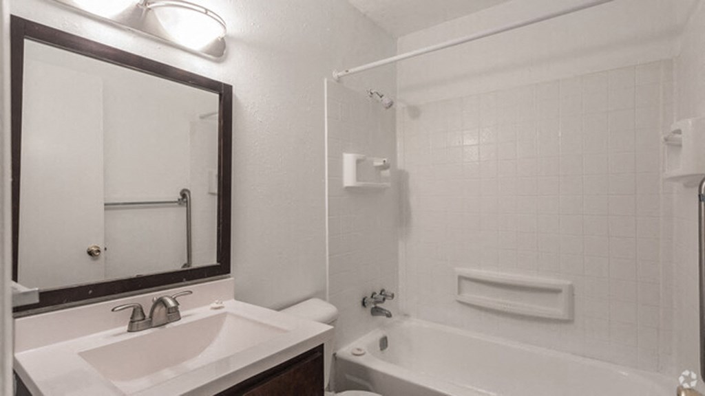 a bathroom with a sink and a tub and a mirror