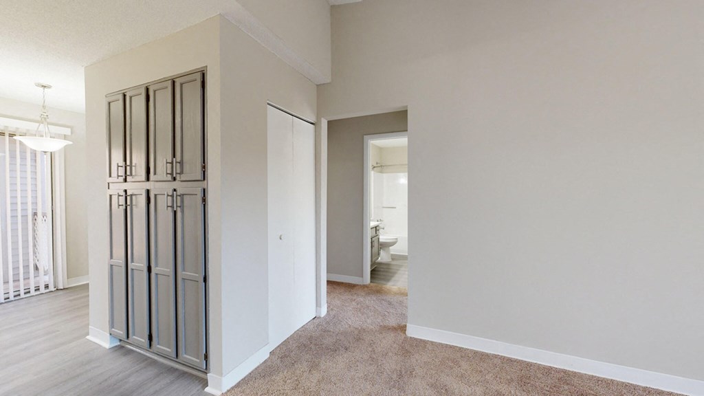 a bedroom with a mirrored closet and a door to a bathroom