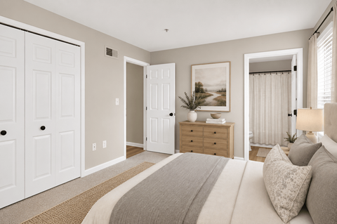 A bedroom with a large bed and a painting on the wall.