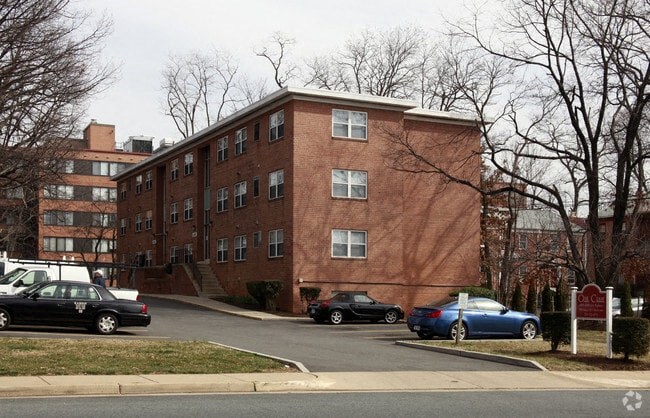 a red brick apartment building with cars parked in front of it