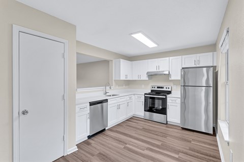 A kitchen with white cabinets and stainless steel appliances.
