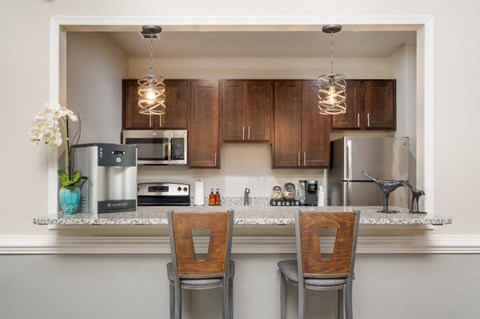a kitchen with a counter top with two chairs