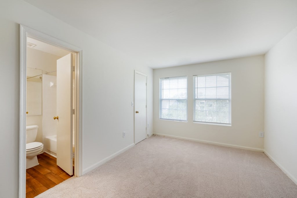 a bedroom with a toilet and a window   and a bathroom