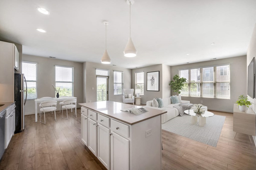 an open kitchen and living room with a white counter top