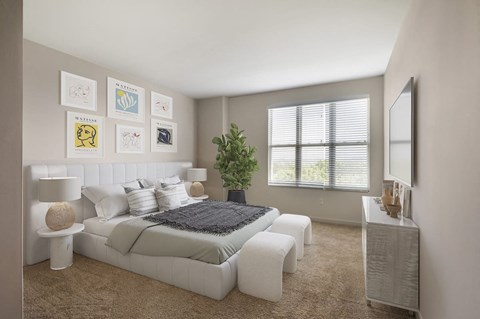 a white bedroom with a bed and a mirror