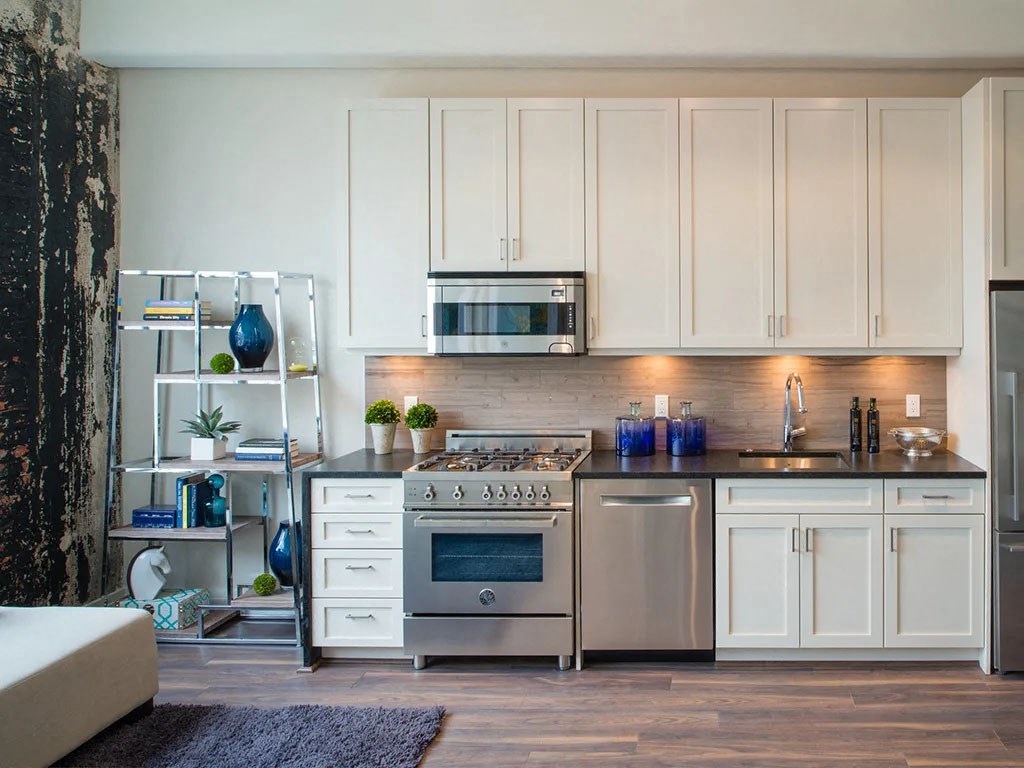 a white kitchen with stainless steel appliances and white cabinets