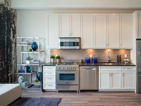 a white kitchen with stainless steel appliances and white cabinets