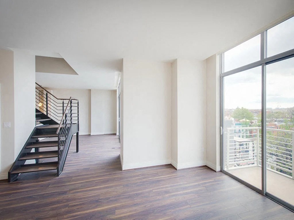a living room with a staircase and a large window