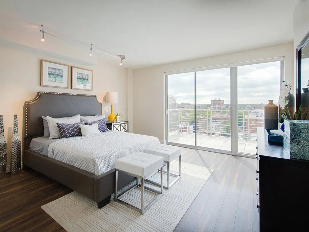 a bedroom with a bed and a large window