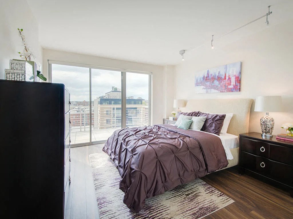a bedroom with a bed and a large window