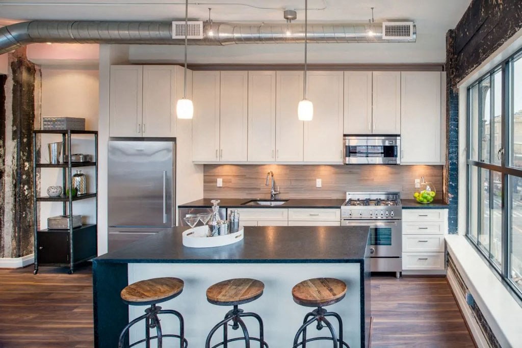 a bar with wooden stools and white walls and a stainless steel railing