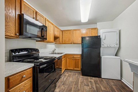 A kitchen with black appliances and wooden cabinets.