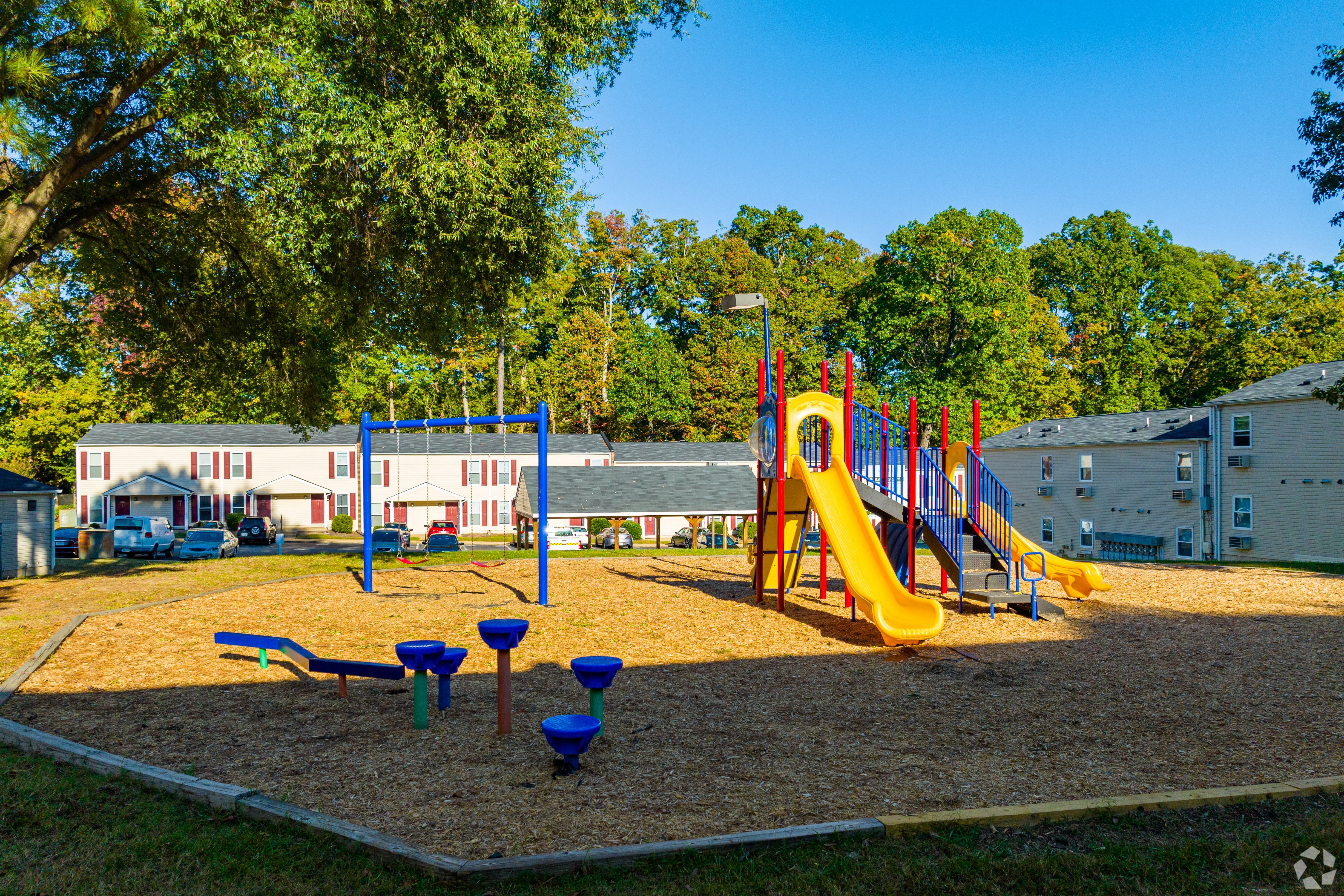 a playground with a swing set and slides in a park