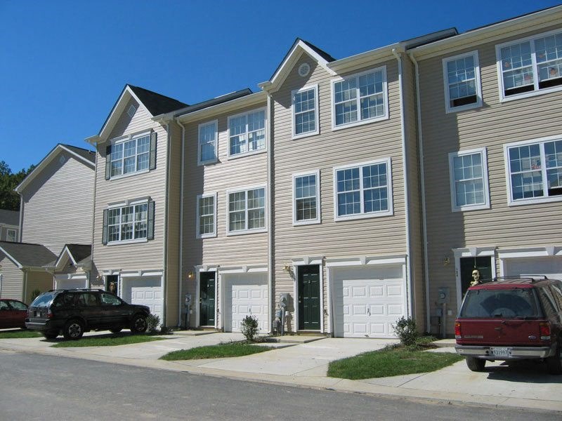 a row of houses with cars parked in front of them