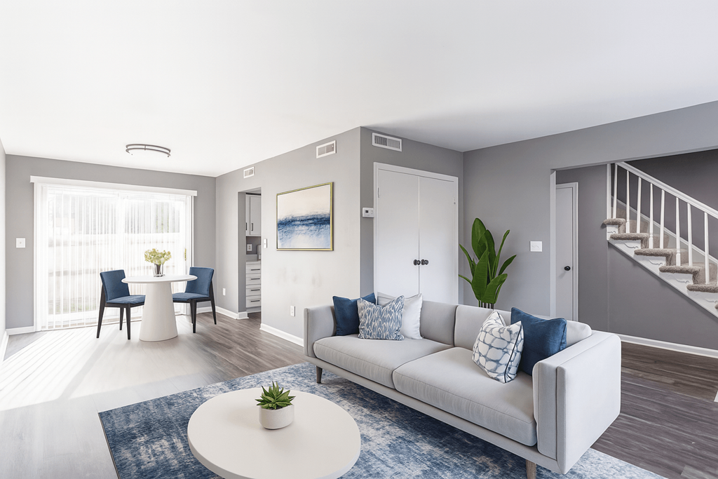 A living room with a white couch and a blue rug.