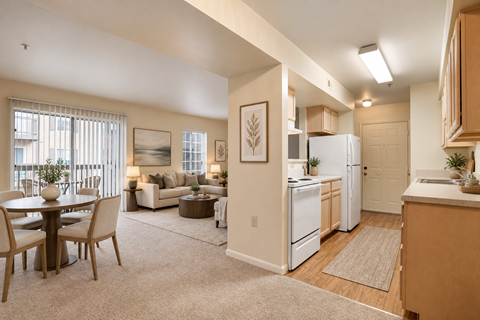 A well-lit, spacious kitchen and living room with modern furniture and appliances.