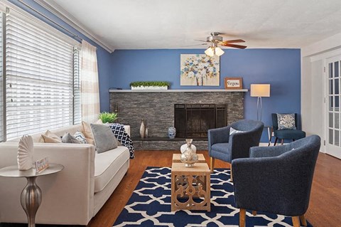 A living room with a fireplace and a painting on the wall.