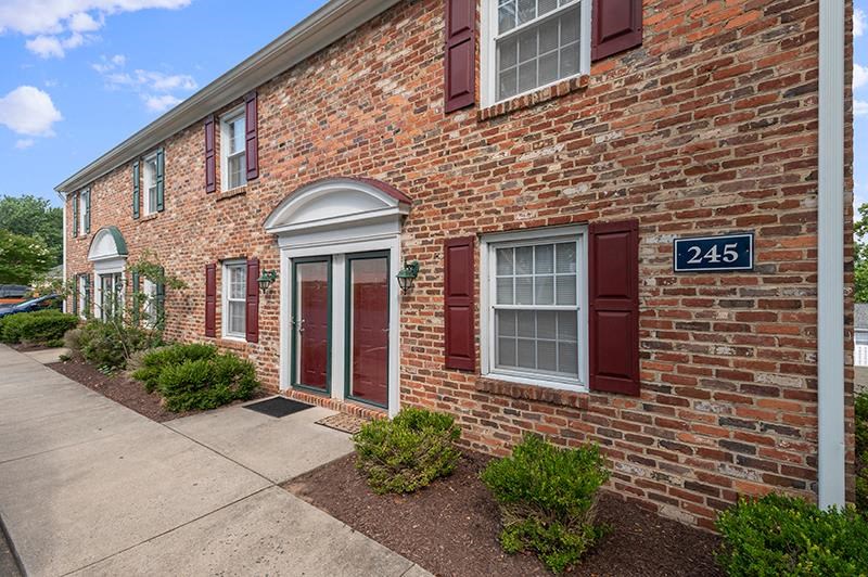 A red brick building with the number 245 on a blue sign.