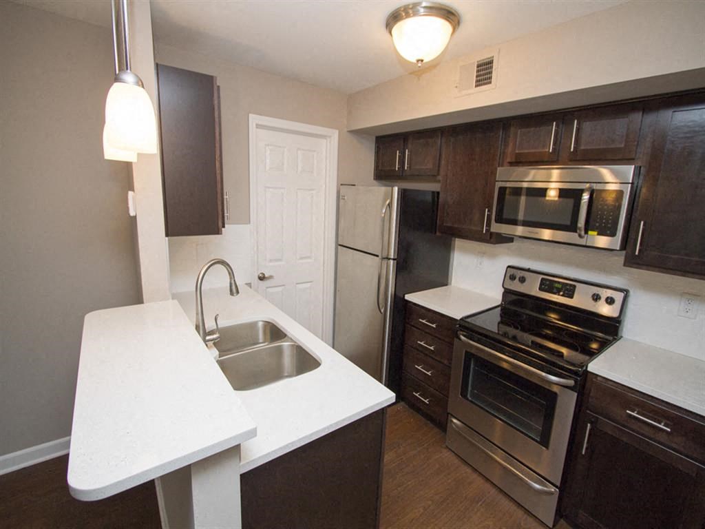 a kitchen with a sink stove refrigerator and microwave
