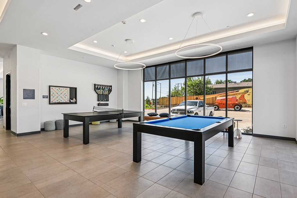 A room with a pool table and a billiard table.