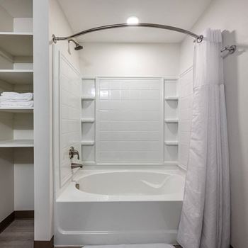 a white bathroom with a tub and a shower curtain