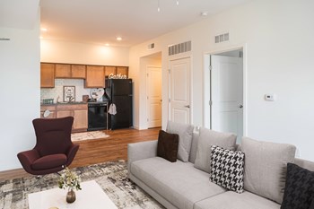 Staged apartment living room and kitchen-Legacy Pointe at Poindexter, Columbus, OH - Photo Gallery 3