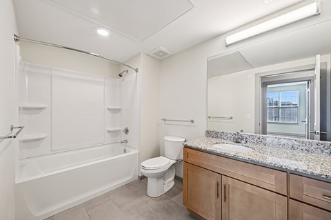 A white bathroom with a tub, toilet, and sink.
