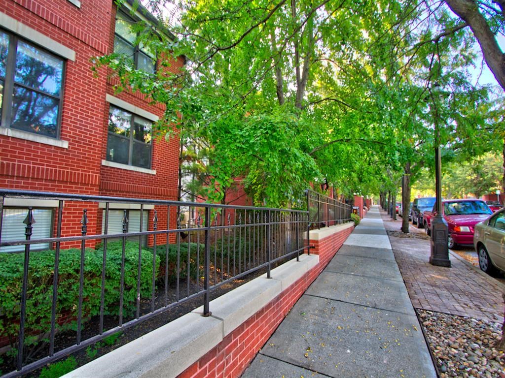 a sidewalk in front of a red brick apartment building