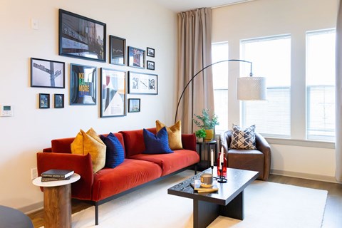 A living room with a red couch and a coffee table.