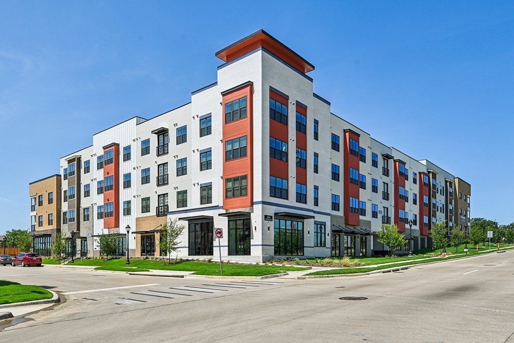 A multi-story apartment building with a red and white roof.
