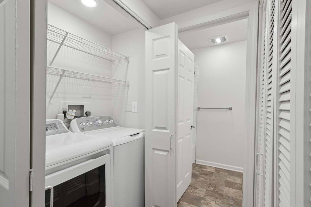 A white kitchen with a stove top oven and a white door.