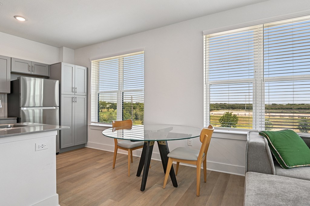 A kitchen with a table and chairs by a window.